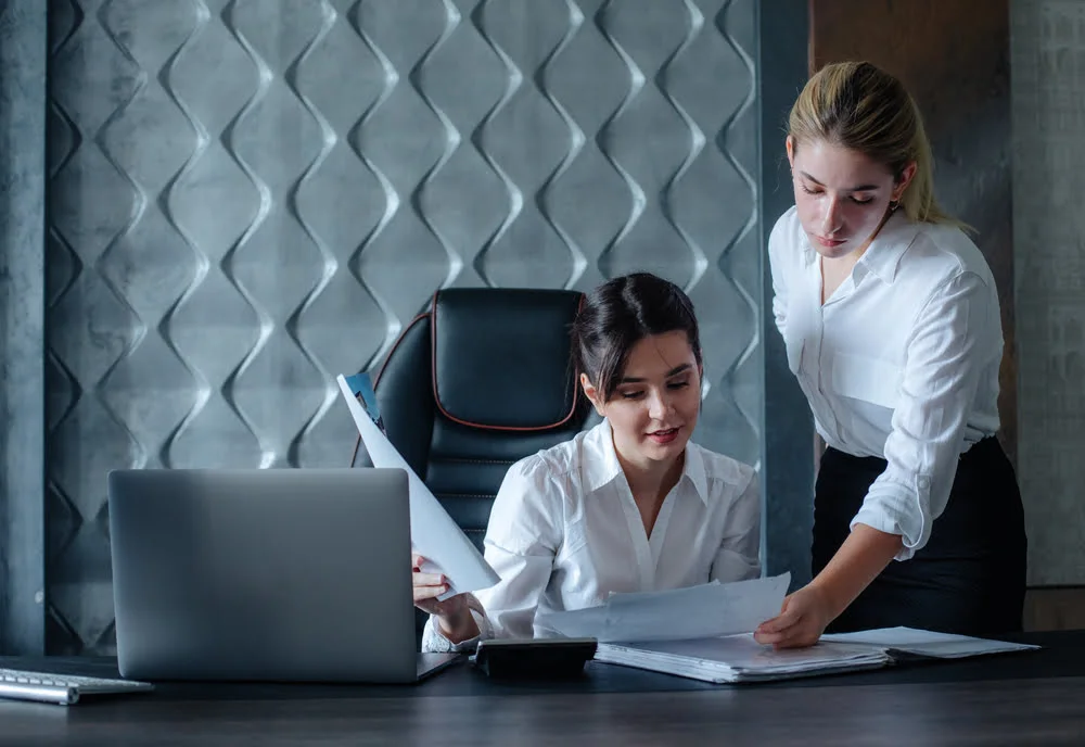 HR colleagues working through employee administration on a laptop